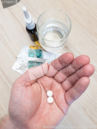 Image of Hand holding pills