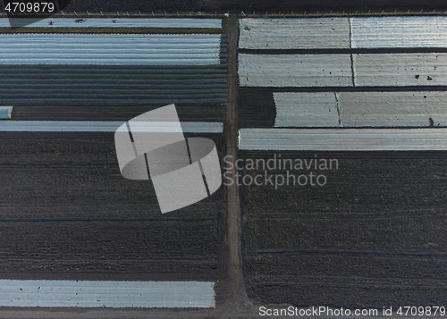 Image of Aerial photo plowed field with greenhouses