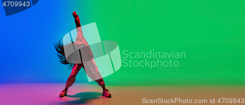 Image of Stylish sportive girl dancing hip-hop in stylish clothes on colorful background at dance hall in neon light. Youth culture, movement, style and fashion, action.