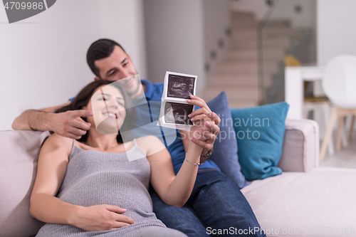 Image of pregnant couple looking baby\'s ultrasound