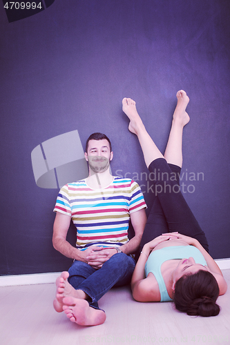 Image of pregnant couple relaxing on the floor