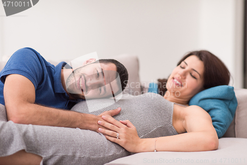 Image of future dad listening the belly of his pregnant wife