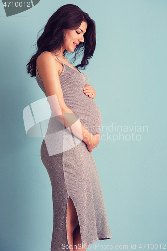 Image of Portrait of pregnant woman over blue background