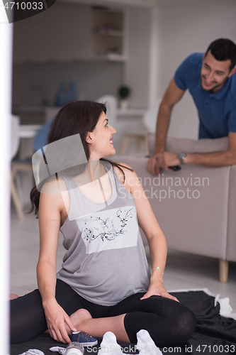 Image of pregnant couple checking a list of things for their unborn baby