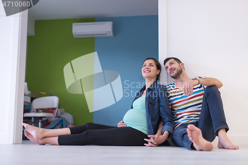 Image of pregnant couple sitting on the floor