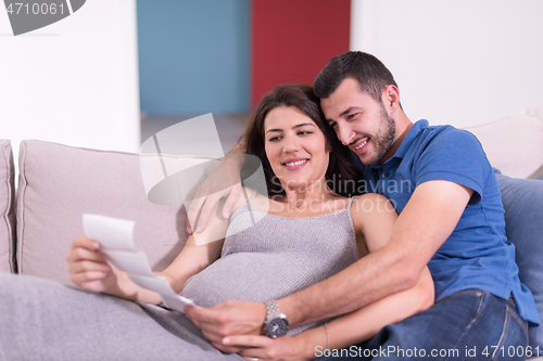 Image of pregnant couple looking baby\'s ultrasound