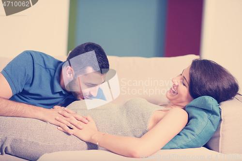 Image of future dad listening the belly of his pregnant wife