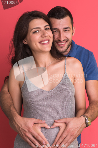 Image of pregnant  couple showing heart with their hands