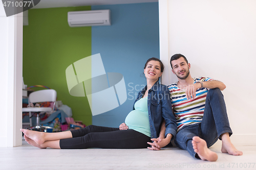 Image of pregnant couple sitting on the floor