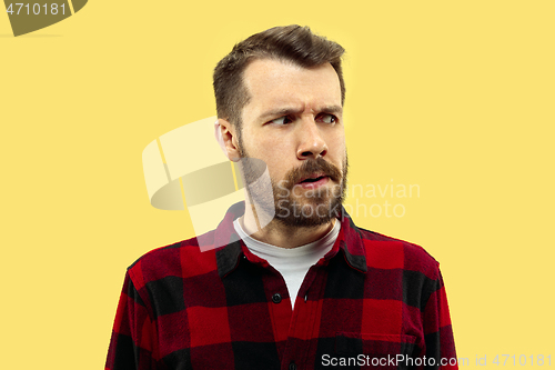 Image of Half-length close up portrait of young man on yellow background.