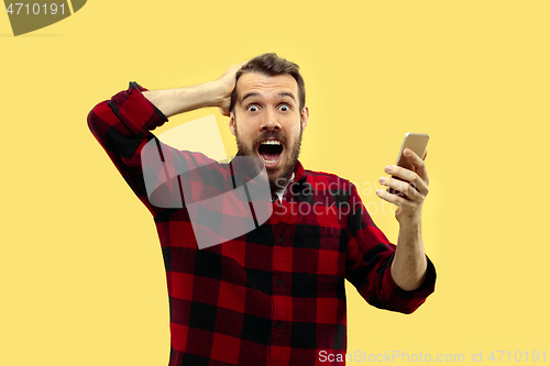 Image of Half-length close up portrait of young man on yellow background.