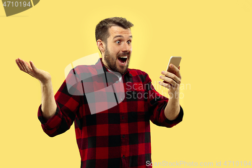 Image of Half-length close up portrait of young man on yellow background.