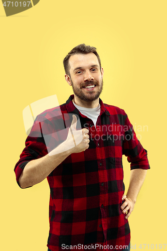 Image of Half-length close up portrait of young man on yellow background.