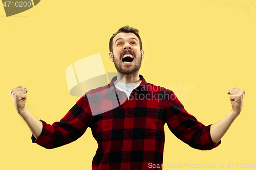 Image of Half-length close up portrait of young man on yellow background.