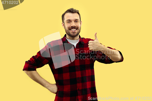 Image of Half-length close up portrait of young man on yellow background.