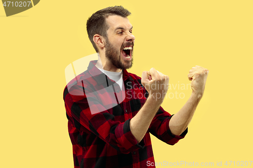 Image of Half-length close up portrait of young man on yellow background.