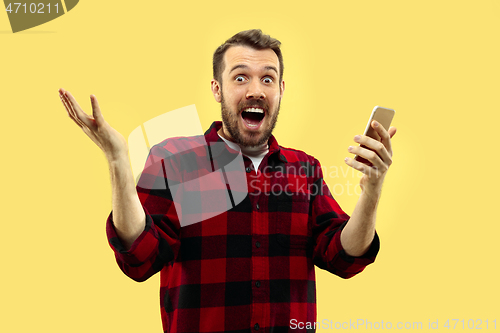 Image of Half-length close up portrait of young man on yellow background.