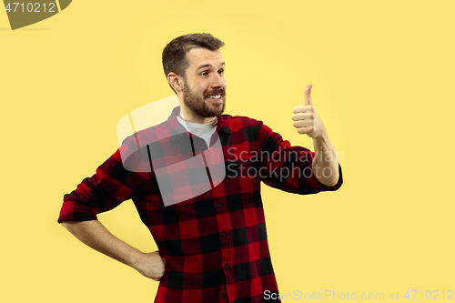 Image of Half-length close up portrait of young man on yellow background.