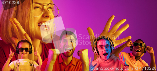 Image of Beautiful young people in neon light isolated on pink studio background