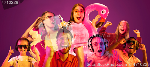 Image of Beautiful young people in neon light isolated on pink studio background