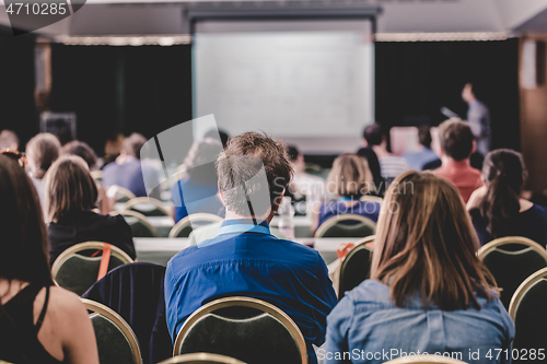 Image of Audience in lecture hall participating at business conference.