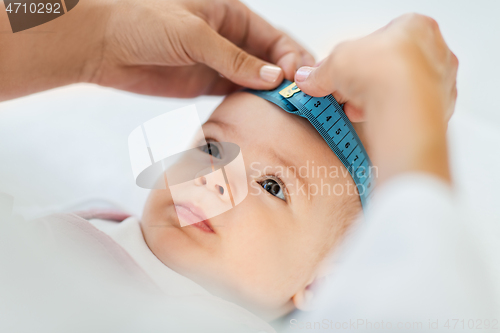 Image of pediatrician doctor measuring bab\'s head at clinic