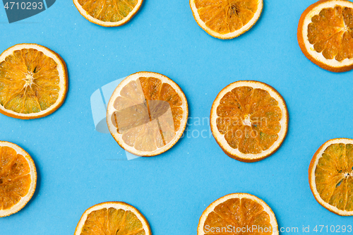 Image of dried orange slices on blue background