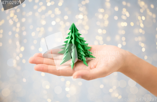 Image of hand holding green paper origami christmas tree