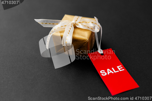 Image of small gift box and red sale tag with discount sign