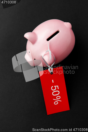 Image of piggy bank with red sale tag on black