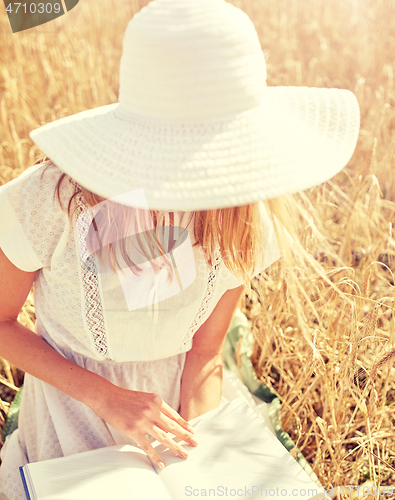 Image of close up of woman reading book on cereal field