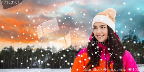 Image of happy young woman in winter clothes outdoors