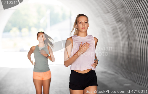 Image of young women or female friends running outdoors