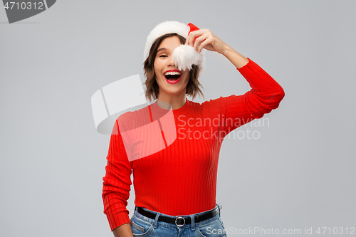 Image of happy young woman in santa hat on christmas