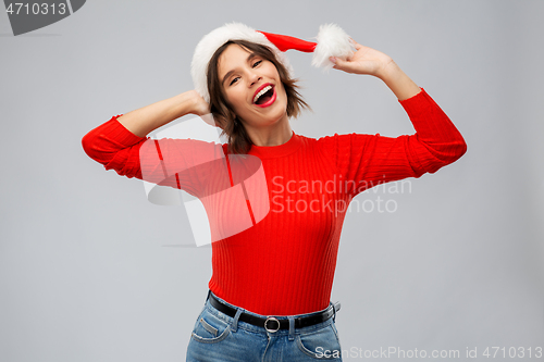 Image of happy young woman in santa hat on christmas