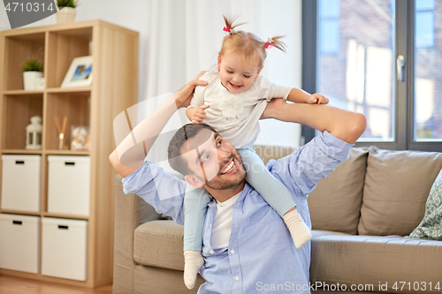 Image of father riding little baby daughter on neck at home