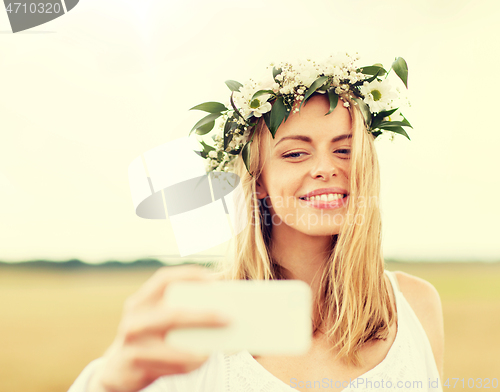 Image of happy young woman taking selfie by smartphone