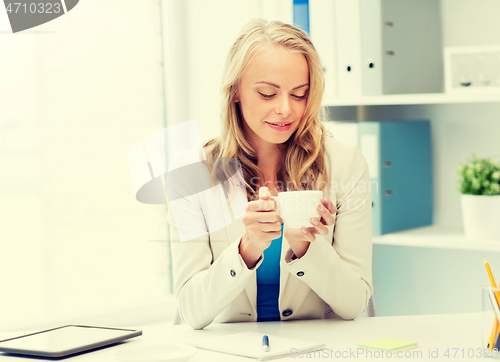 Image of happy businesswoman drinking coffee at office