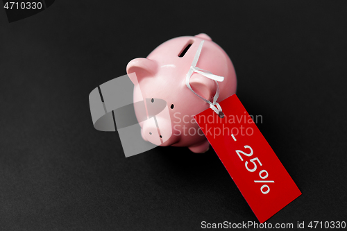 Image of piggy bank with red sale tag on black