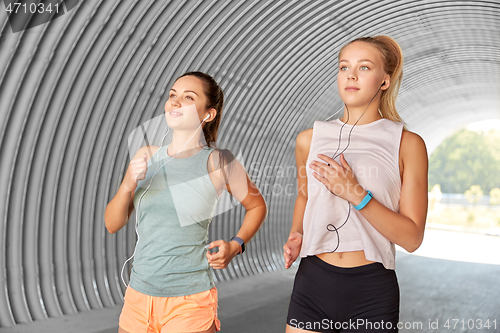 Image of women or female friends with earphones running