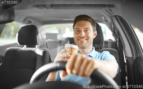 Image of man or driver with takeaway coffee cup driving car