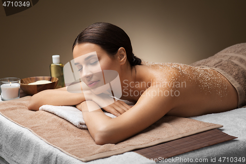 Image of woman lying with sea salt on skin at spa