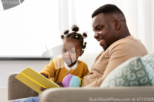 Image of african father reading book for baby daughter