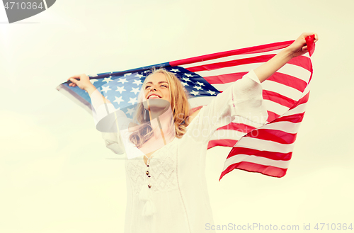 Image of happy young woman with american flag outdoors