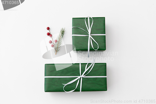 Image of green gift boxes and fir tree branch with berries