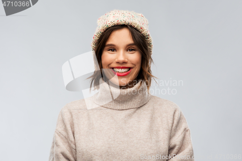 Image of young woman in knitted winter hat and sweater