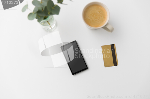 Image of smartphone, credit card and cup of coffee