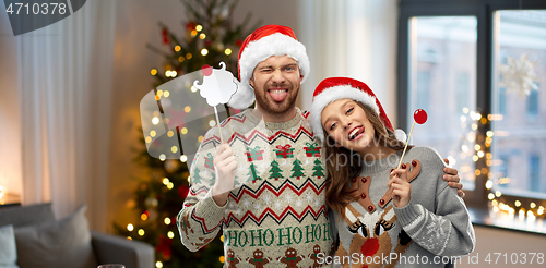 Image of couple with christmas party props in ugly sweaters