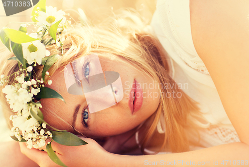 Image of happy woman in wreath of flowers on cereal field