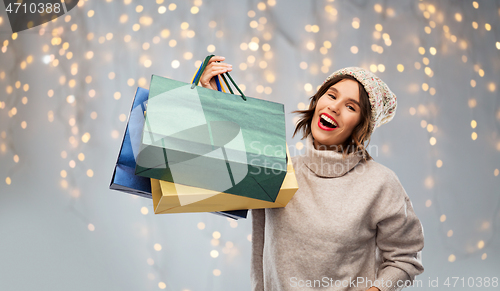 Image of young woman in hat with shopping bags on christmas